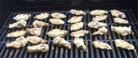 chicken wings cooking on a gas grill