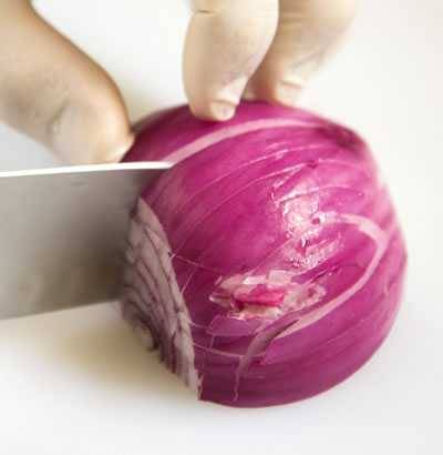 slicing downward on the onion