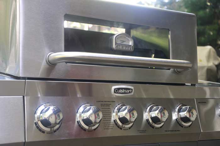 Gas grill hood with a window in front.