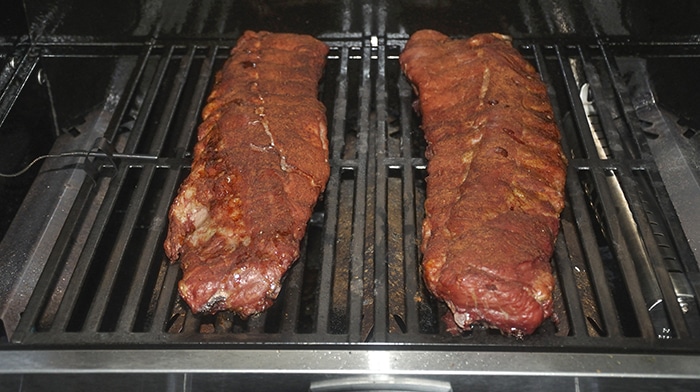 Two slabs of ribs on a grill grate.