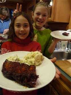 kids holding up a plate of barbecue