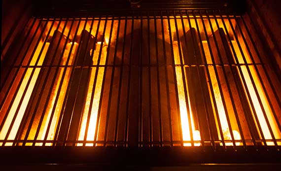Barbecue grill with lid up and glowing flames.