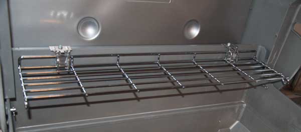 A shiny, metal rack sticking out from a shiny, metal vertical surface.