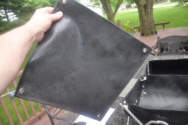 hand holding a black leathery rectangular flap.