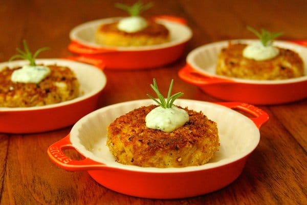 Grilled crab cakes in serving dishes topped with aioli