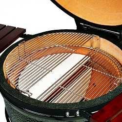 Round kamado from above with lid up to show the inside. There are two half-moon shaped steel rod cooking grates placed at different levels and twp half-moon shaped white objects under the grates.