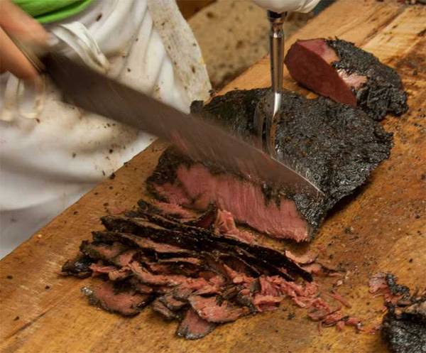 slicing pastrami on cutting board