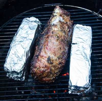 boneless leg of lamb on grill with bricks to crisp the edges