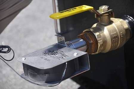 A black box with a brass ball valve sticking out. A metal object labeled "BBQ Guru" is attached to the valve.