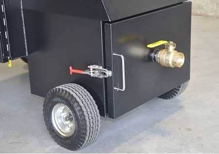 A black box with wheels on the bottom. A door is clamped shu with a red latch. A brass ball valve sticks out of the door.