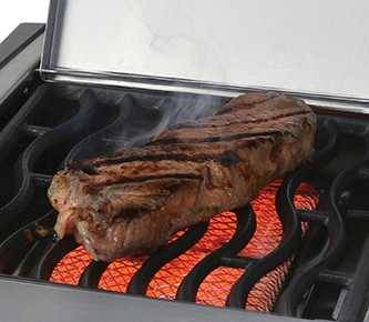Black wavy cooking grates over a glowing rectangular burner with a steak sizzling on top.