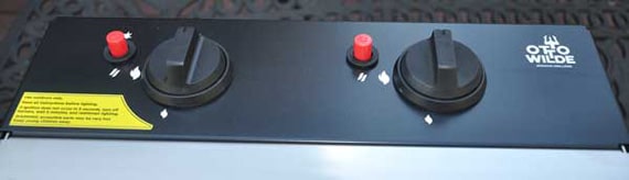 Black panel with two control knobs and two red buttons.