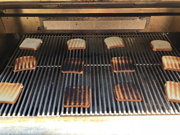 Slices of toasted bread on a bbq grill.