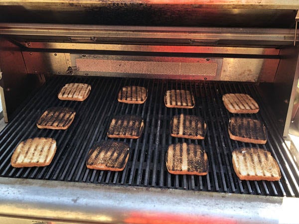 Slices of toasted bread on a bbq grill.