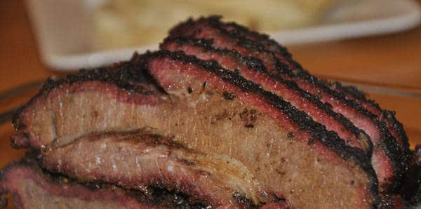 Sliced beef brisket with pink smoke rings around the edges.
