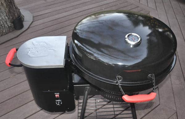 Black kettle grill from above. A black box with a shiny lid is attached to the left side.