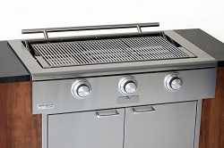 Shiny steel gas grill with no lid mounted in a wood cabinet.