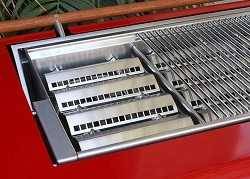 Shiny arched metal plates with rows od holes in side a red gas grill.