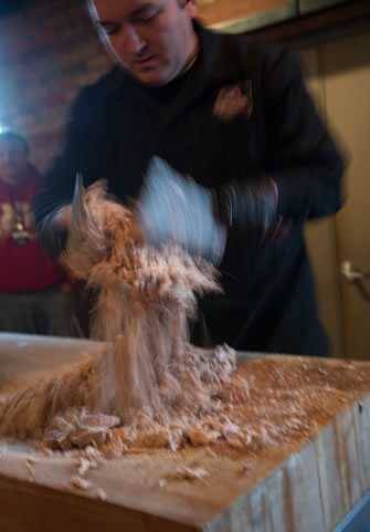 Sam Jones chopping meat from a smoked hog