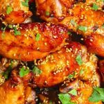 Grilled miso chicken wings topped with sesame seeds and cilantro