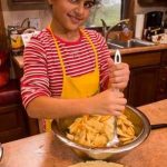 Child stirring apple pie filling