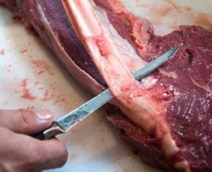 Removing the silverskin from a whole beef tenderloin with a filet knife
