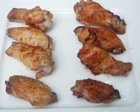 Pale and crispy brown chicken wings on a white plate