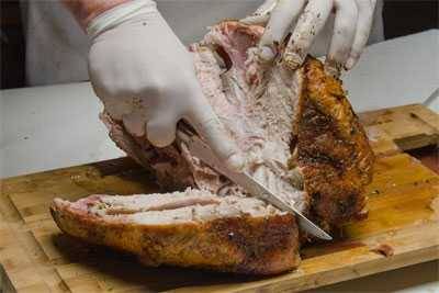 slicing breast meat from a turkey