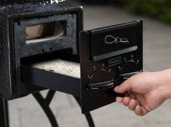 A hand sliding a small tray out from a black structure.