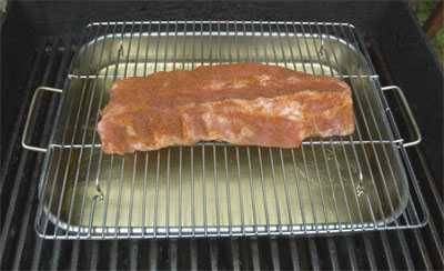 ribs on a gas grill with broiler rack and broiler pan underneath
