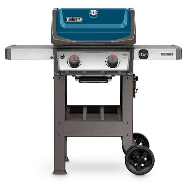 Small gas grill with light blue hood mounted on four legs with two wheels. Shelves are attached to each side.