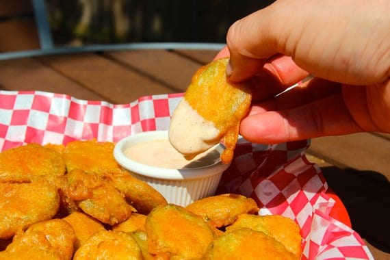 Deep fried pickle dipped into Sriracha ranch sauce