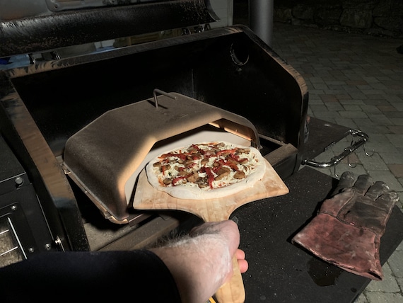 loading pizza into Green Mountain Grills pizza attachment