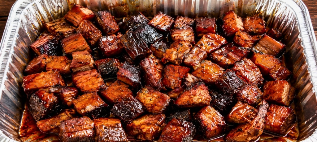 Sauced brisket burnt ends in an aluminum pan