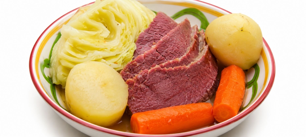 Sliced corned beef, cabbage, potatoes, and carrots in a bowl.