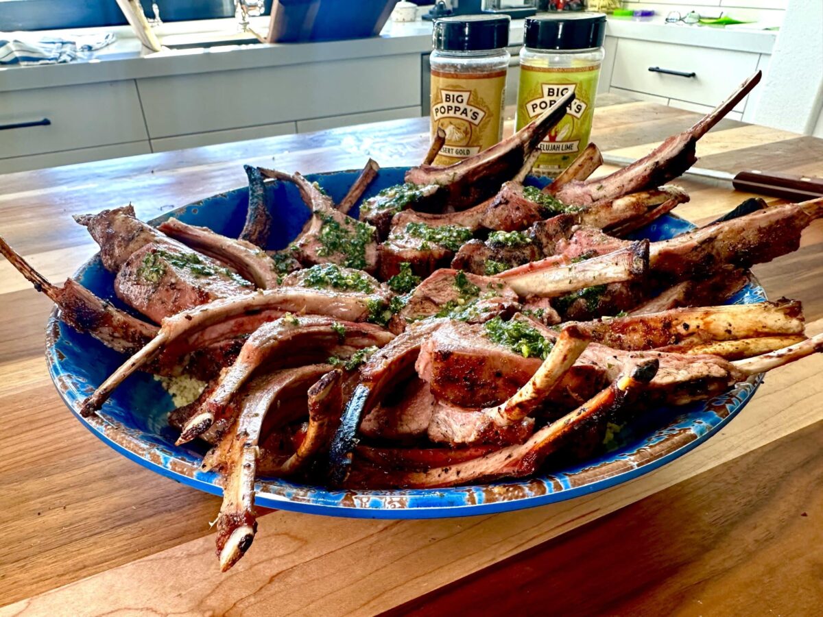 Plated lamb chops with chimichurri sauce.