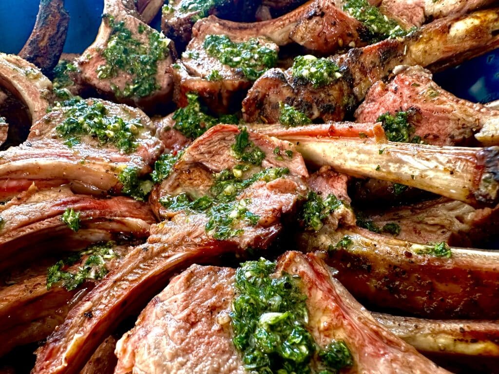 Close-up of lamb chops with chimichurri sauce.