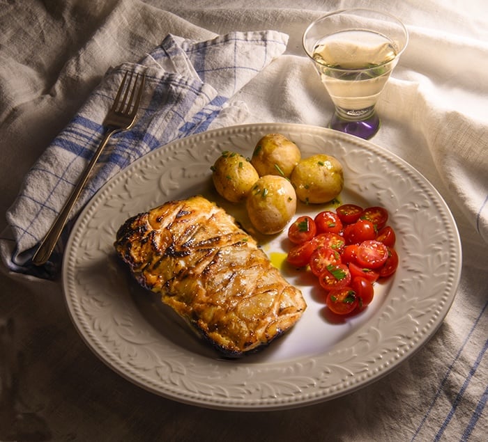 miso maple salmon a la nobu on a plate with potatoes and tomatoes