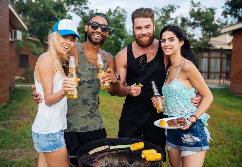 Cheering happy people at the grill holding beers
