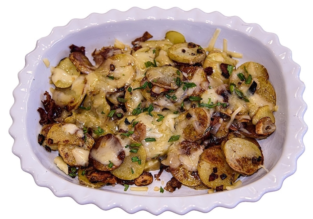 griddle potatoes with prosciutto and smoked gouda on a white plate.