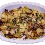 griddle potatoes with prosciutto and smoked gouda on a white plate.