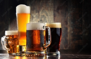 four different beer glasses filled with four different beers