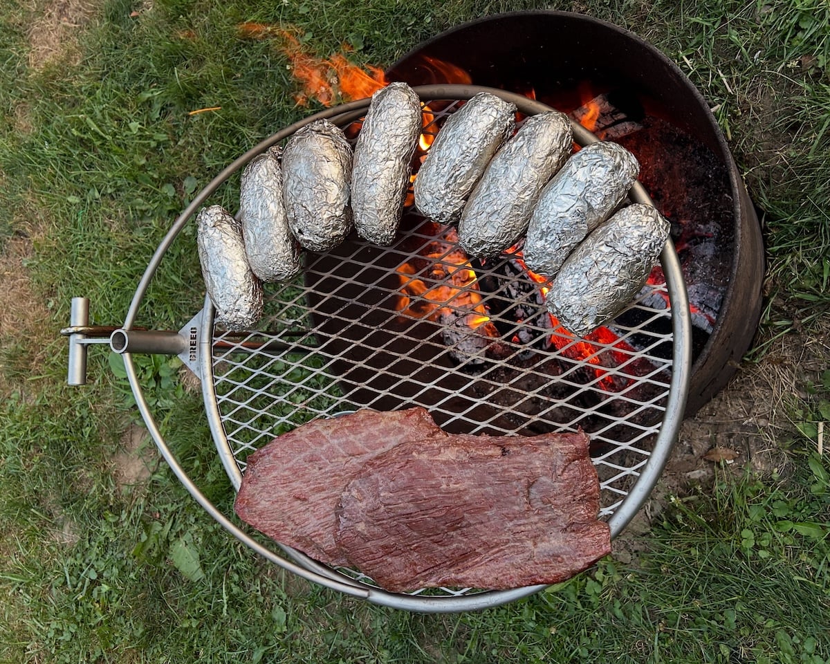 Breeo flank steak and foil wrapped potatoes on the Outpost Grill