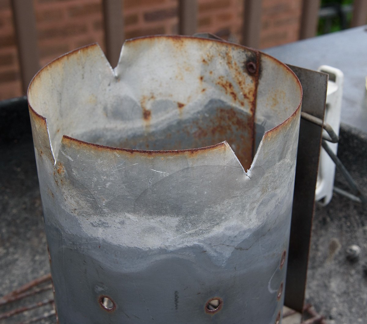 charcoal chimney with holes cut near the top
