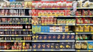 Processed food including dried pasta and canned tomatoes on a grocery store shelf