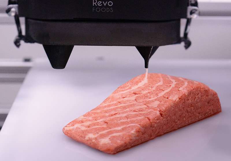 A piece of salmon being made by a machine
