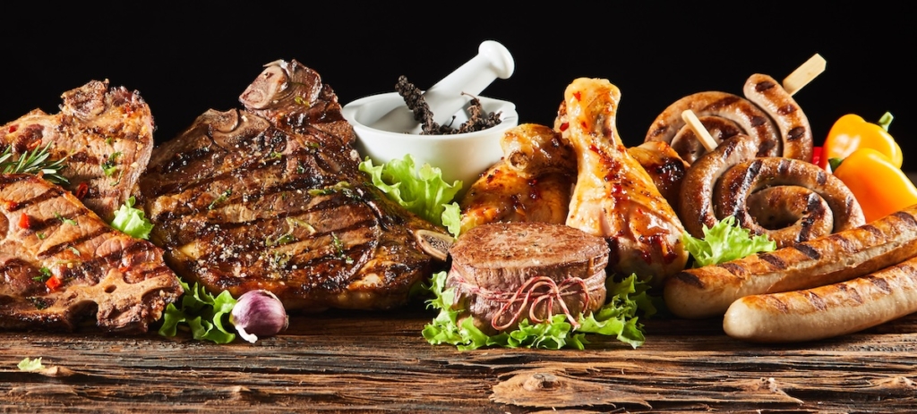 Barbecued meats and poultry on a wooden board
