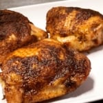 spice rubbed smoked chicken thighs on a white plate