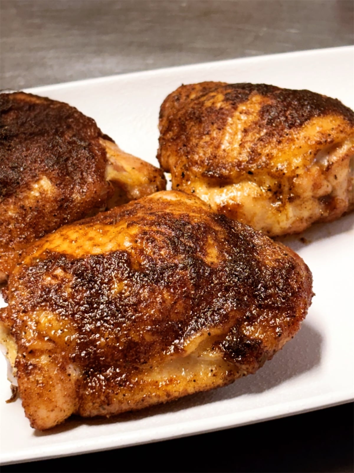 spice rubbed smoked chicken thighs on a white plate