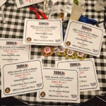 National Barbecue & Grilling Association Awards for AmazingRibs.com spread out on a table.